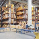 Automobile dealership inventory manager conducting a physical stock audit of vehicle spare parts using barcode scanners and ERP inventory software.